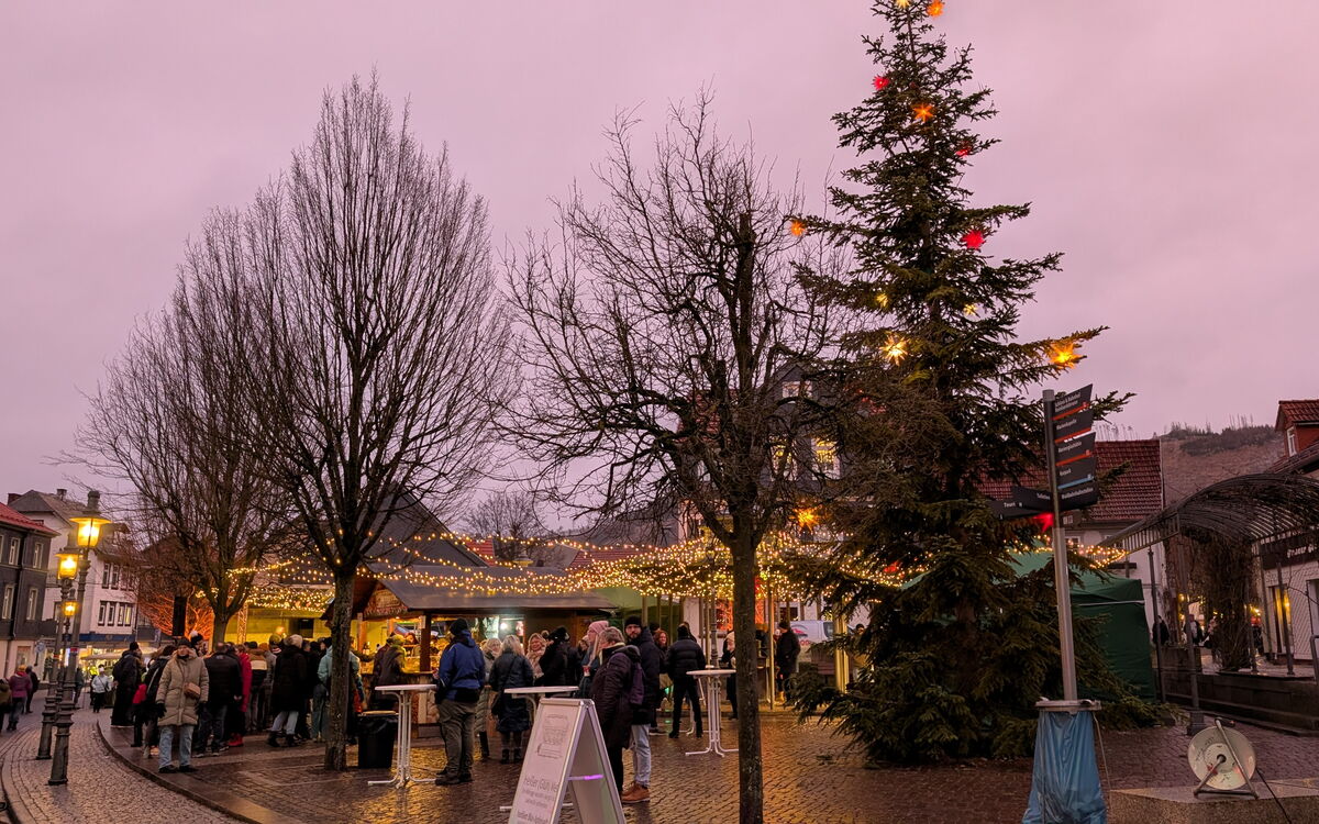 erleuchteter Kirchplatz mit Ständen und Menschen