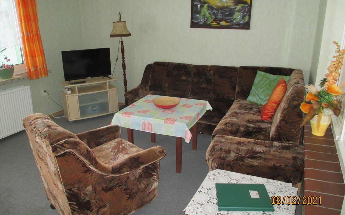 Wohnzimmer mit Sofa, Tisch und Fernseher