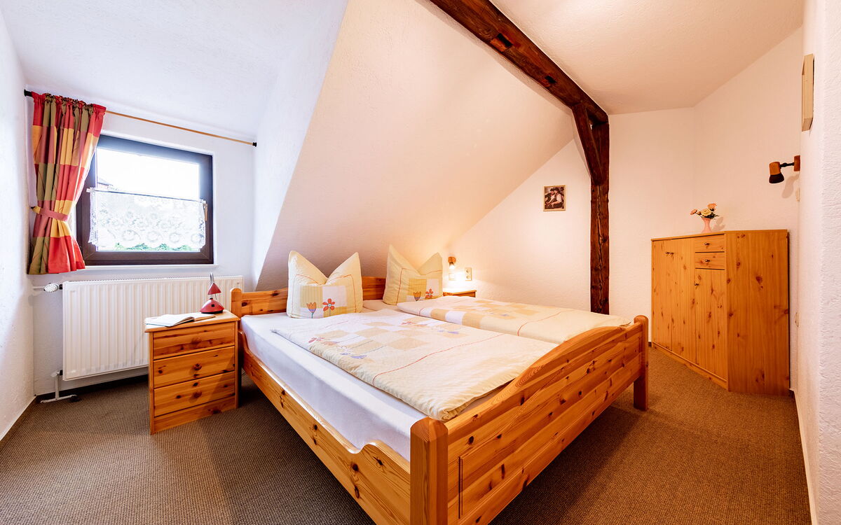 Schlafzimmer mit Doppelbett und Fachwerkbalken