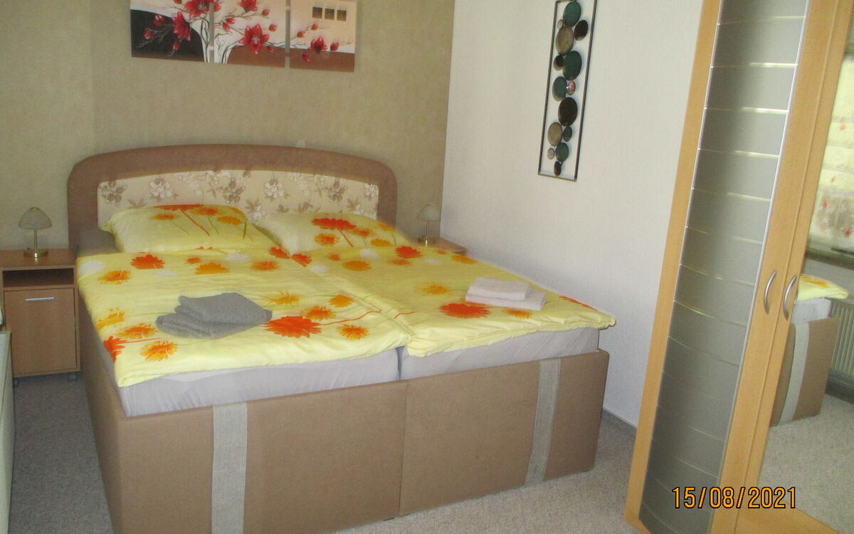 Schlafzimmer mit Doppelbett und Schrank